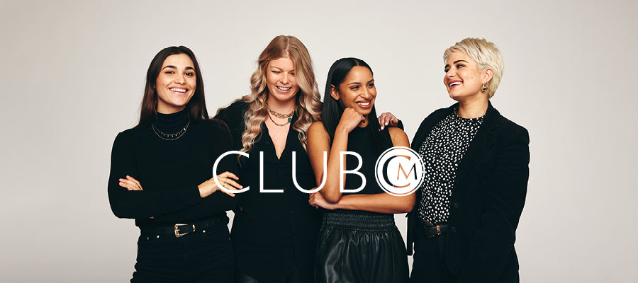 Four women posing together with 'CLUB M' logo overlayed on a plain background